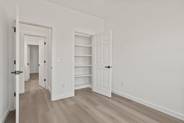 unfurnished bedroom featuring light hardwood / wood-style flooring and a closet