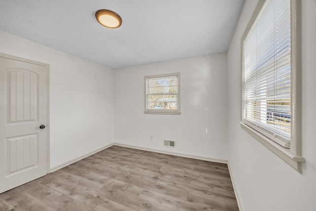 spare room with a wealth of natural light and light wood-type flooring