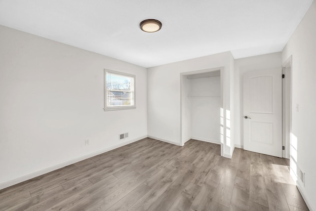 unfurnished bedroom with a closet and light wood-type flooring