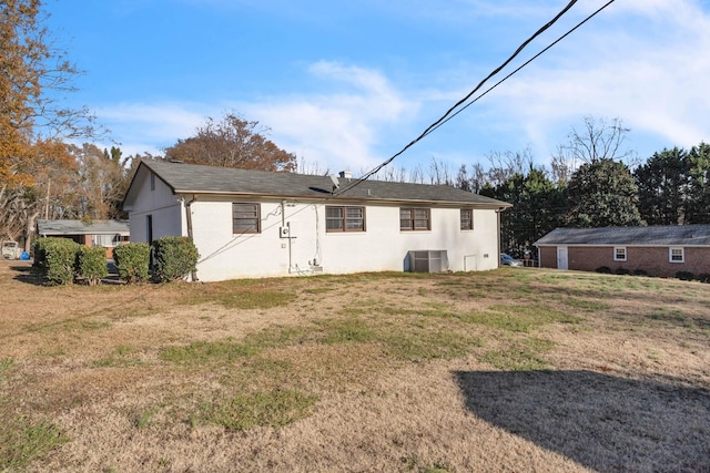 back of property featuring a yard and cooling unit