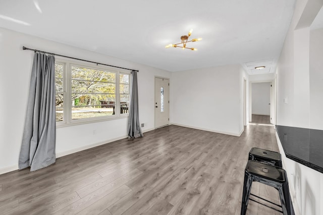 unfurnished living room with hardwood / wood-style flooring and an inviting chandelier