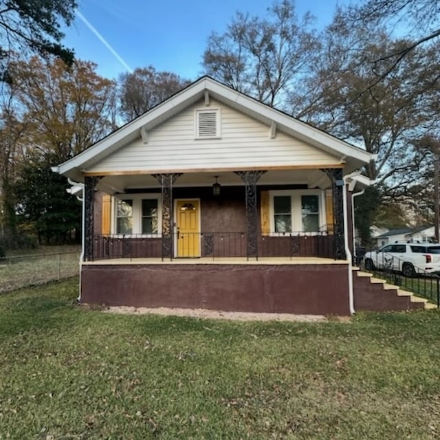 bungalow-style home featuring covered porch and a front lawn