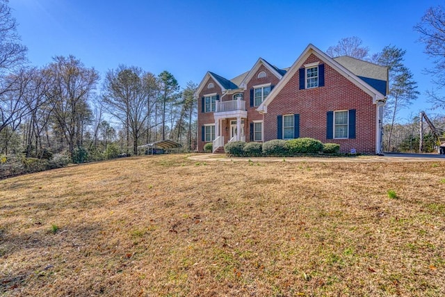 view of front of house with a balcony and a front lawn