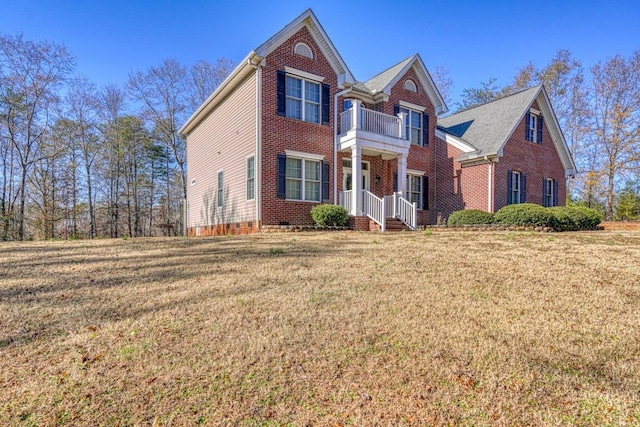 view of front property with a balcony and a front lawn