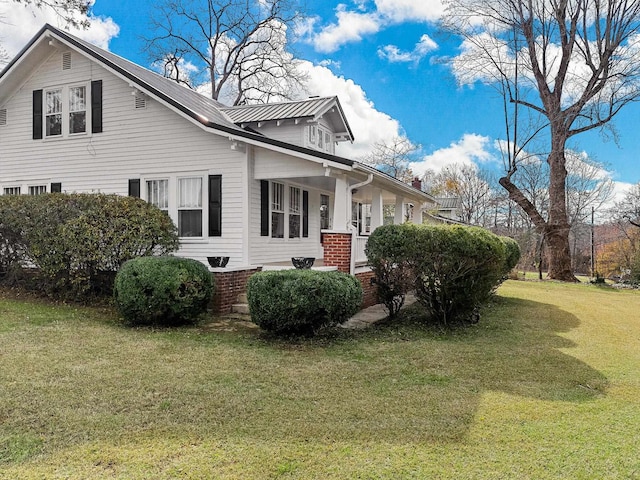 view of property exterior with covered porch and a lawn