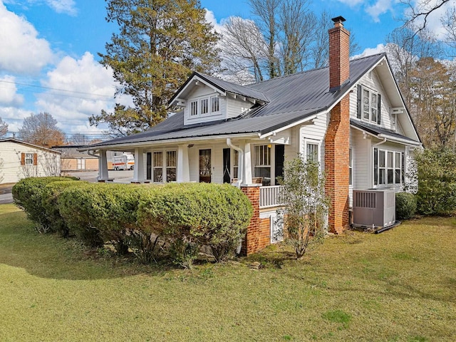 exterior space featuring a lawn, covered porch, and central AC