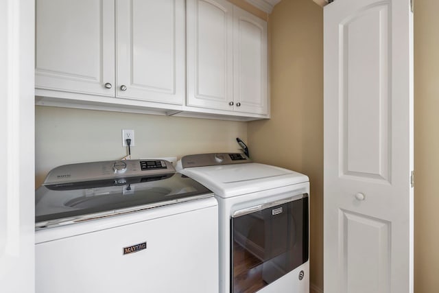 laundry area with washer and clothes dryer and cabinets