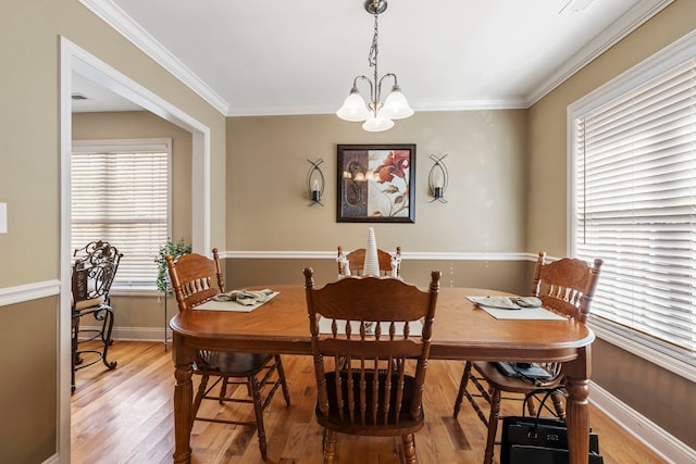 dining room featuring a chandelier, hardwood / wood-style floors, and crown molding