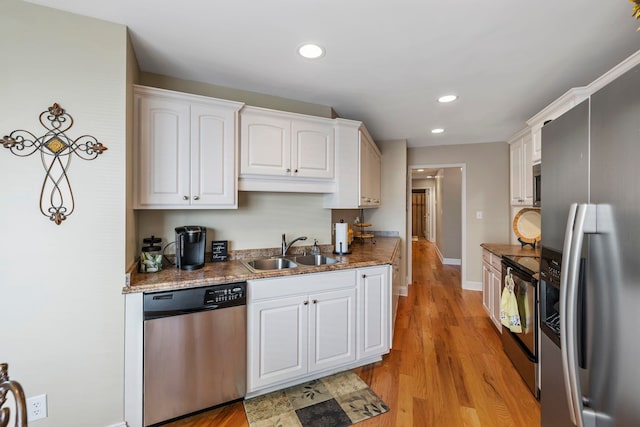 kitchen featuring sink, white cabinets, light hardwood / wood-style flooring, and appliances with stainless steel finishes