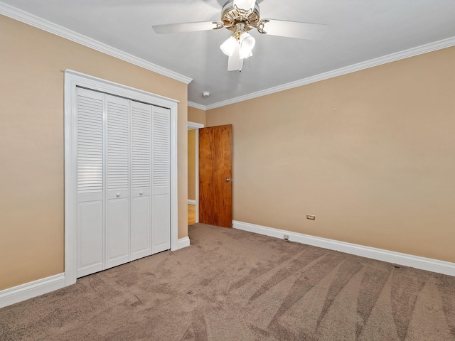 unfurnished bedroom featuring a closet, ceiling fan, crown molding, and carpet