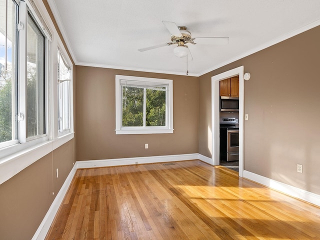 empty room with ceiling fan, wood-type flooring, and crown molding