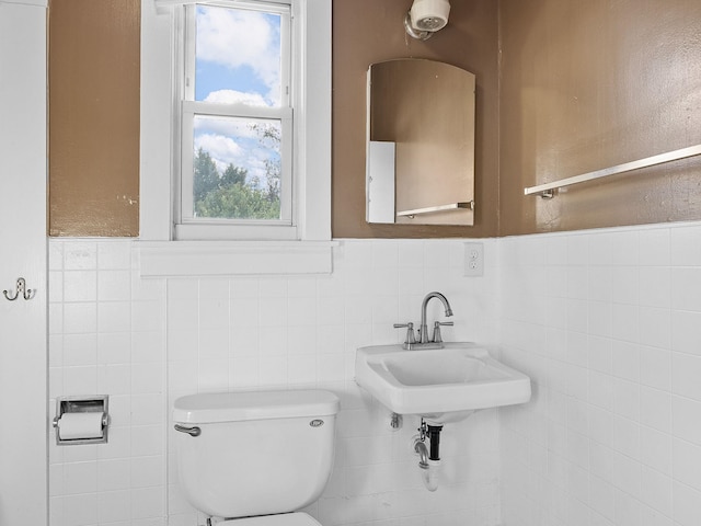 bathroom with toilet and tile walls