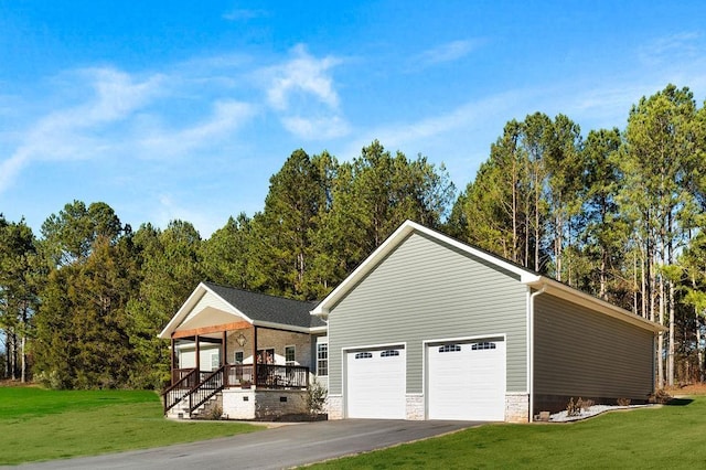 exterior space with a porch, a garage, and a front lawn