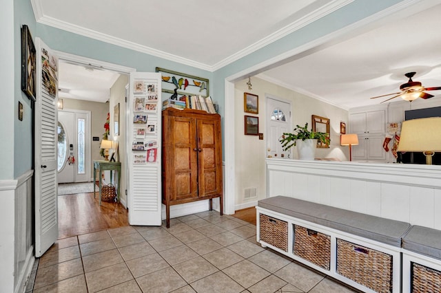 interior space featuring ceiling fan, crown molding, and light wood-type flooring