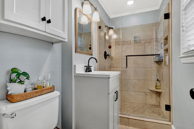 bathroom with vanity, toilet, a shower with door, and ornamental molding