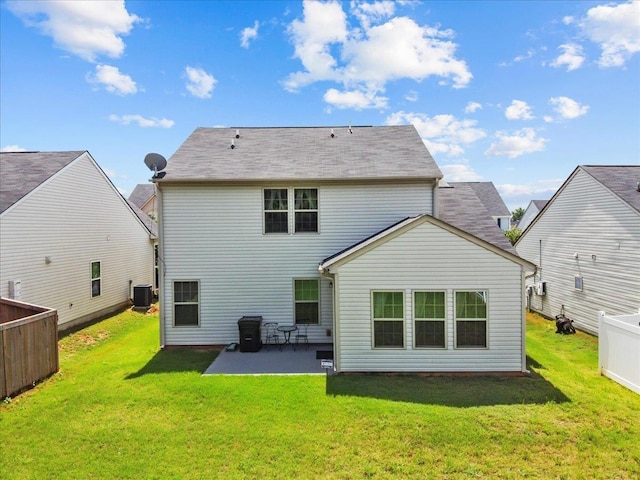 rear view of house with a lawn, cooling unit, and a patio