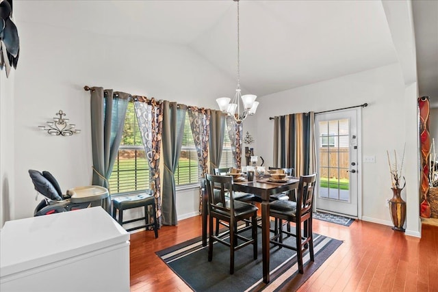 dining room featuring wood-type flooring, an inviting chandelier, and lofted ceiling