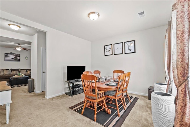 carpeted dining room with ceiling fan