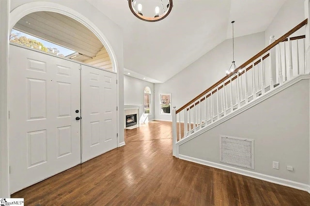 foyer with wood-type flooring, lofted ceiling, and a notable chandelier