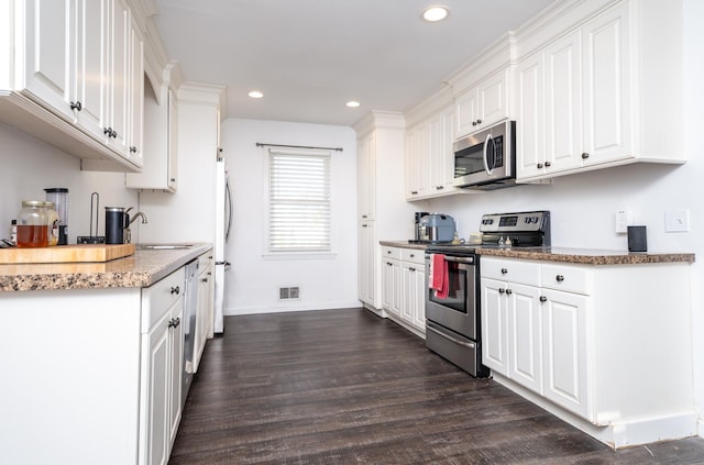 kitchen featuring stone counters, white cabinets, sink, dark hardwood / wood-style floors, and appliances with stainless steel finishes