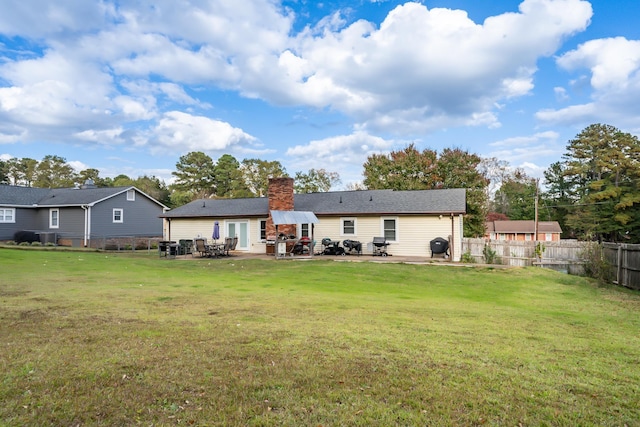 rear view of house featuring a patio area and a lawn