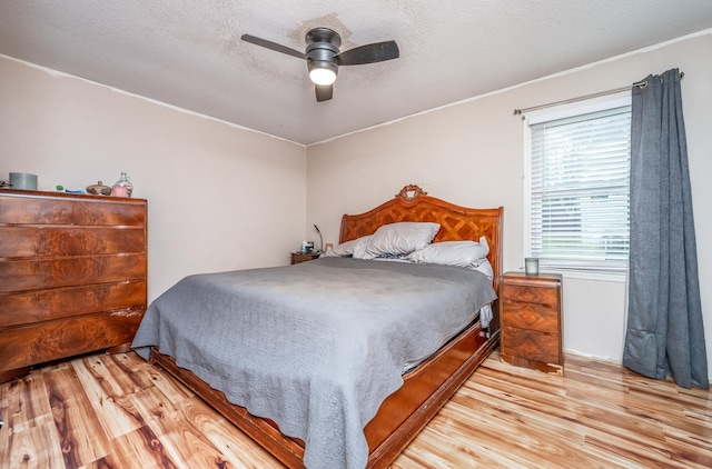 bedroom with ceiling fan, light hardwood / wood-style flooring, and a textured ceiling