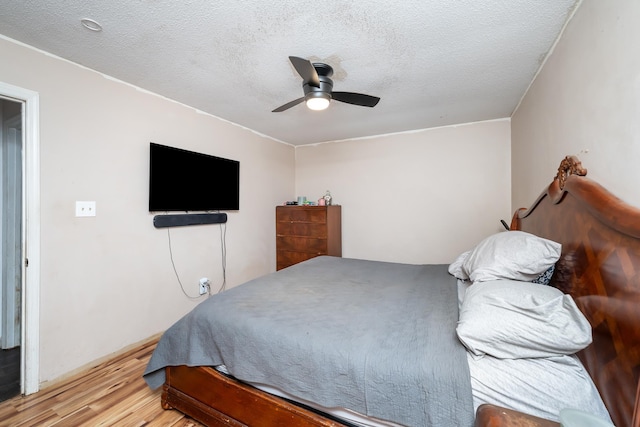 bedroom with a textured ceiling, light hardwood / wood-style floors, and ceiling fan