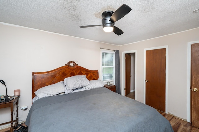 bedroom featuring a textured ceiling, light wood-type flooring, and ceiling fan