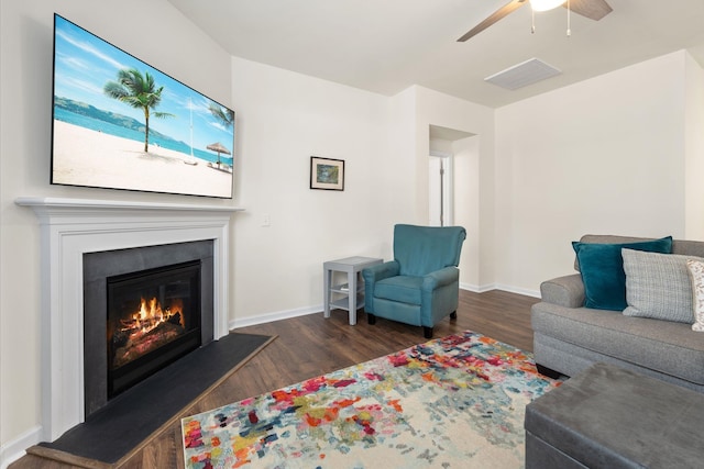 living room with ceiling fan and dark wood-type flooring