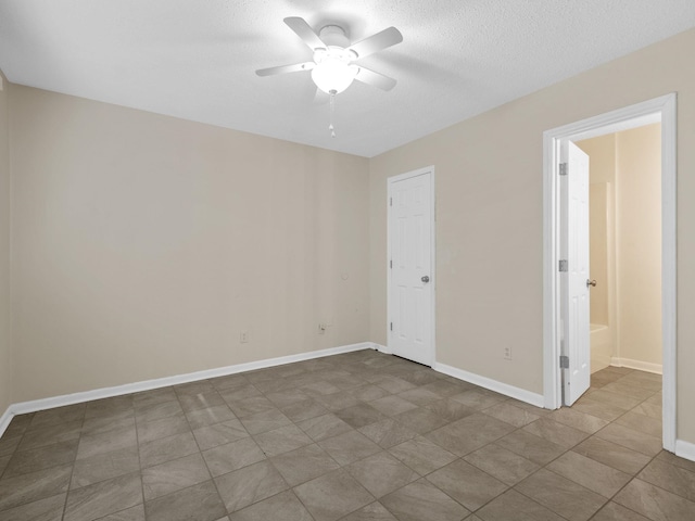 unfurnished room with a textured ceiling, tile patterned floors, and ceiling fan