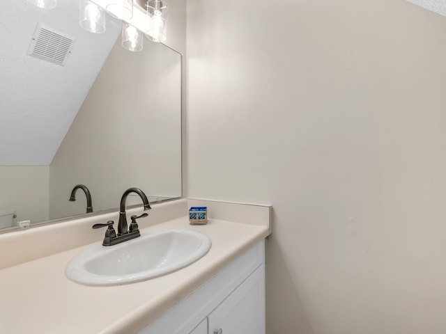 bathroom with vanity and lofted ceiling