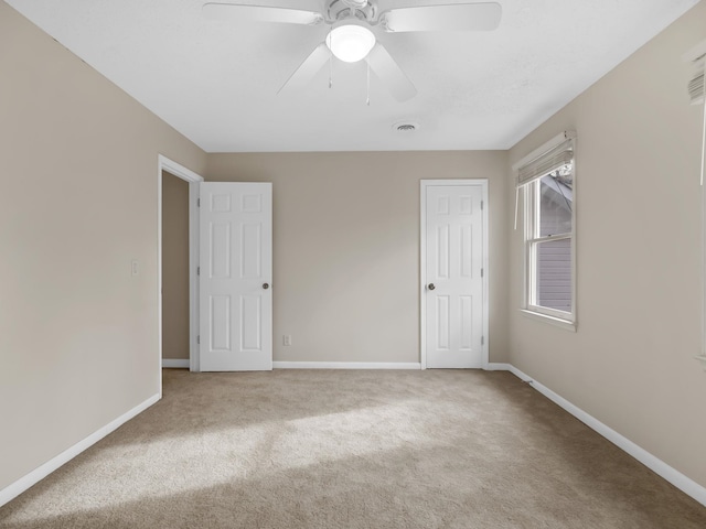 carpeted empty room with ceiling fan