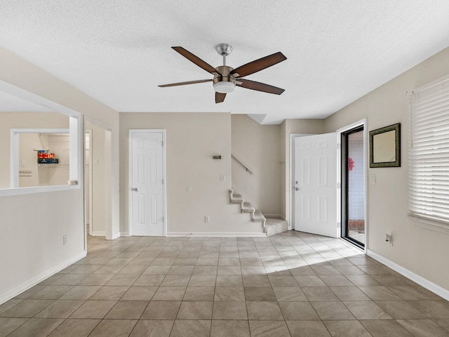 foyer entrance featuring ceiling fan, a healthy amount of sunlight, and a textured ceiling