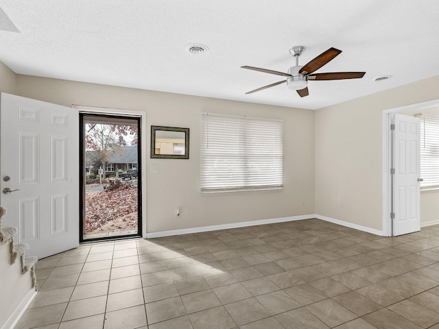 entrance foyer with ceiling fan, light tile patterned floors, and a textured ceiling