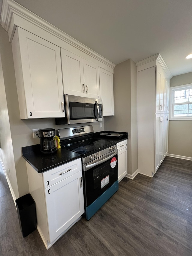 kitchen with white cabinets, dark hardwood / wood-style flooring, and stainless steel appliances