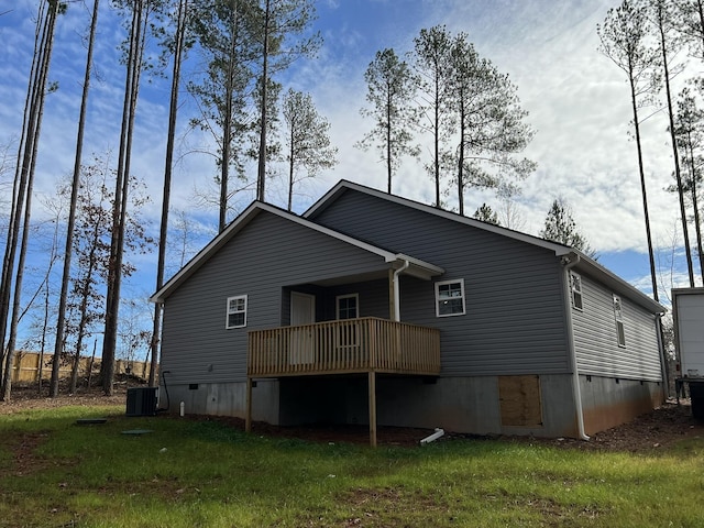 rear view of house with cooling unit and a yard