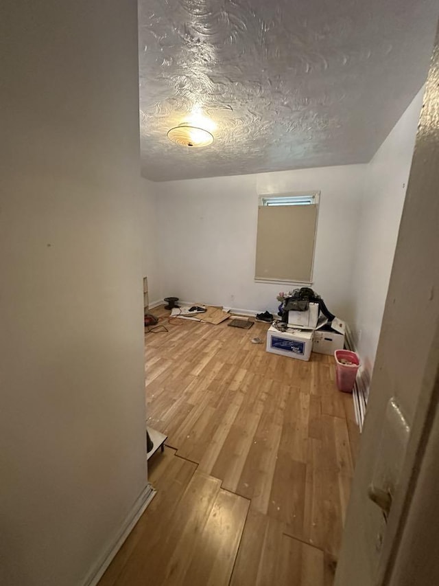 unfurnished room featuring hardwood / wood-style floors and a textured ceiling