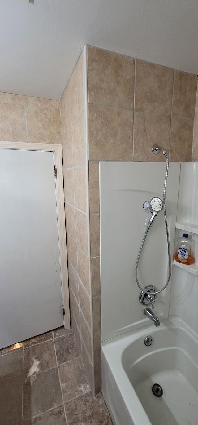 bathroom with tile walls and bathing tub / shower combination