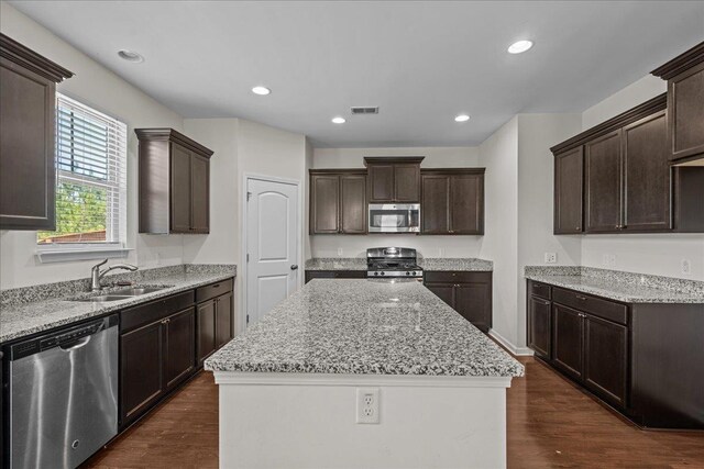 kitchen featuring dark hardwood / wood-style floors, dark brown cabinets, sink, and appliances with stainless steel finishes