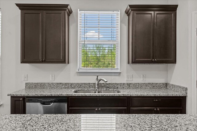 kitchen featuring light stone counters, dishwasher, dark brown cabinets, and sink