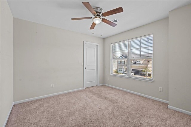 spare room featuring ceiling fan and light carpet