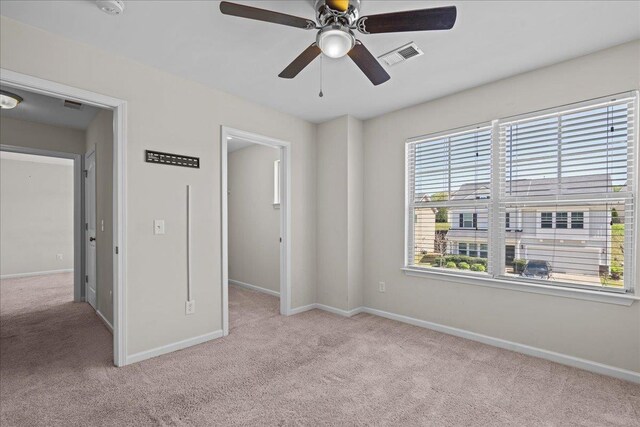 unfurnished bedroom featuring light carpet and ceiling fan