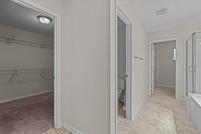 bathroom with a shower with door and toilet