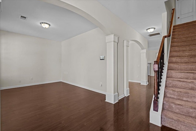 interior space with dark hardwood / wood-style flooring and ornate columns