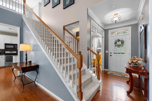 entrance foyer featuring hardwood / wood-style floors and crown molding