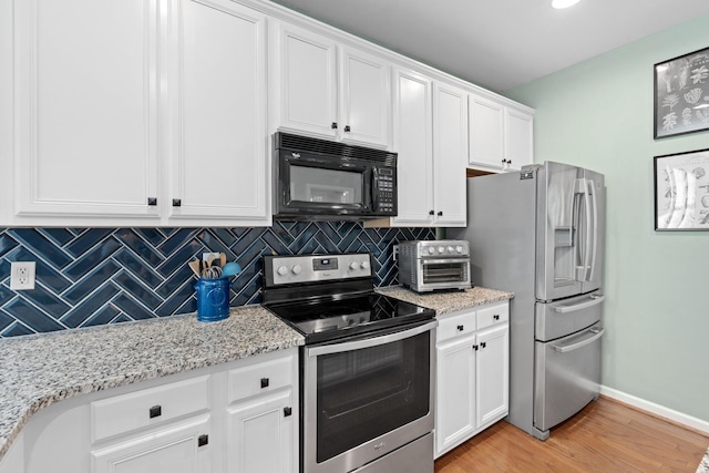 kitchen featuring light stone countertops, light hardwood / wood-style flooring, white cabinets, and stainless steel appliances