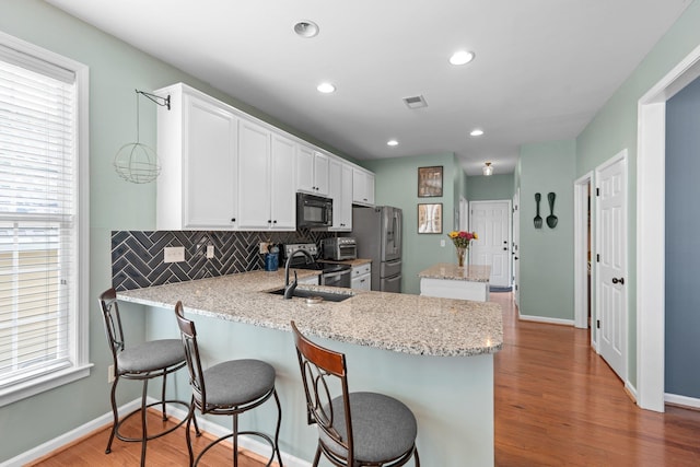 kitchen featuring a healthy amount of sunlight, sink, kitchen peninsula, and stainless steel appliances