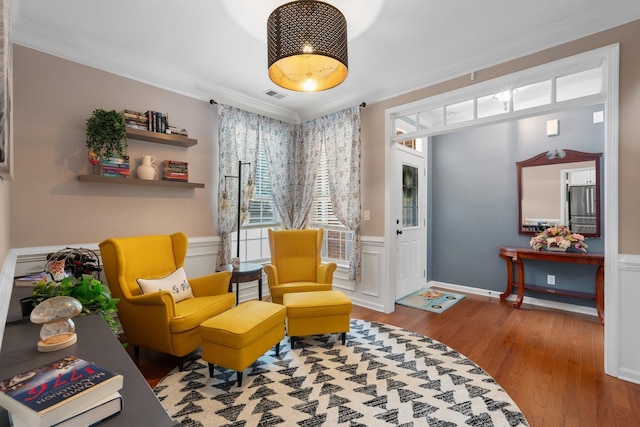 living area featuring crown molding and hardwood / wood-style floors