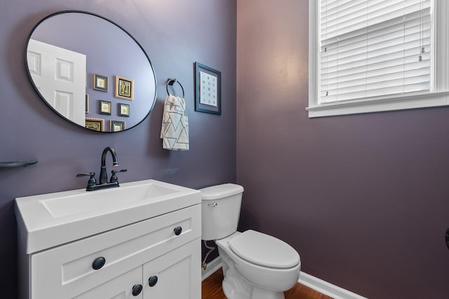 bathroom with hardwood / wood-style floors, vanity, and toilet