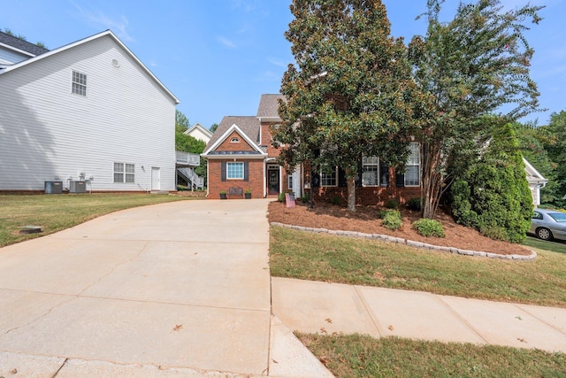 view of front of property with a front yard and central air condition unit